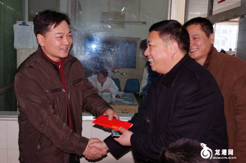 图为龙港镇副镇长吕存阳(右)为龙城中医院院长尤良俊(左)送上慰问金