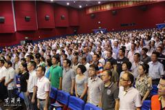 现场奏国歌，全体起立。