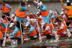 现场锣鼓声响，河两岸人头攒动，各色花船、龙舟逐波东魁河上