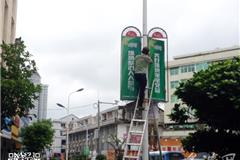 一工作人员正在拆卸户外广告牌